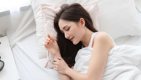 Portrait of sleeping young asia woman enjoy and relax lying on the bed with close eyes in bedroom at home.asian beautyの写真素材
