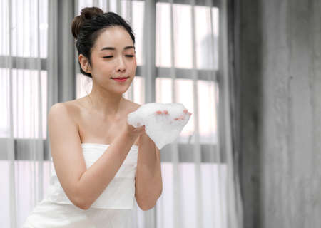 Beautiful young asia woman enjoy relaxing taking a bath with bubble foam in bathtub at the bathroom