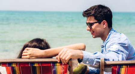 Romantic lovers young couple relaxing together on the tropical beach.Man talk with a girl on...
