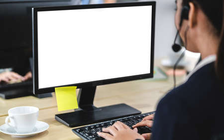 Beautiful businesswoman customer support services working with headset and computer with white mockup blank screens at call centerの写真素材