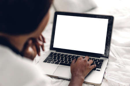 Young african american black woman relaxing and using laptop computer with white mockup blank screens.woman checking social apps and working.Communication and technology conceptの写真素材
