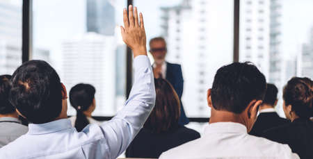 Businessman standing in front of group of people in consulting meeting conference seminar and showing hand to answer question at hall or seminar room.presentation and coaching conceptの写真素材