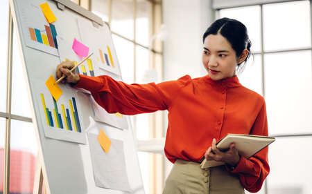 Casual business woman planning and brainstorm writing over the project with stickers note on white board at modern officeの写真素材