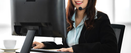 Beautiful happy smiling businesswoman operator customer support phone services working with headset and computer at call centerの写真素材