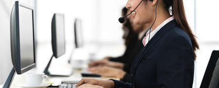 Group of happy smiling business operator customer support team phone services working with headset and computer at call centerの写真素材