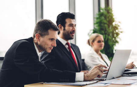 Group of professional business meeting and discussing strategy with new startup project on laptop computer.Creative business people management planning and brainstorm with document report in modern workloft.Teamwork conceptの写真素材