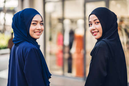 Portrait of happy arabic two friend muslim woman with hijab dress smiling and talking together at storeの写真素材