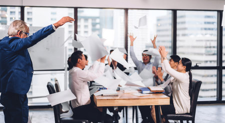 Successful group of casual business relaxing and throwing paper in modern work loft.Creative business people celebrating with arms up.Teamwork and success conceptの写真素材