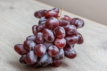 Bunch of red grapes on a wooden background