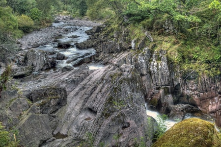 Rocks surround a flowing stream in Scotlandの写真素材