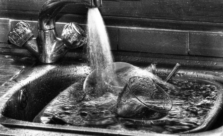 filling up water basin full of dirty dishesの写真素材