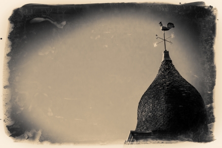 A golden wind vane above a church in the sunshineの写真素材