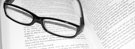 A close up shot of glasses on a bookの写真素材