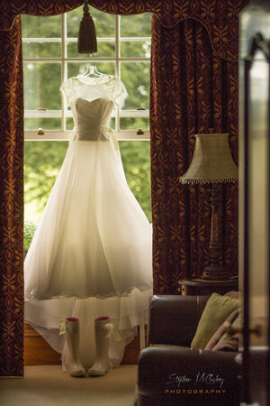 Wedding Dress hanging by windowの写真素材