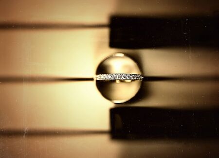 Artistic shot of wedding rings on old pianoの写真素材