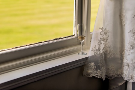 A shot of a wedding Dress and Empty Champagne Glassesの写真素材