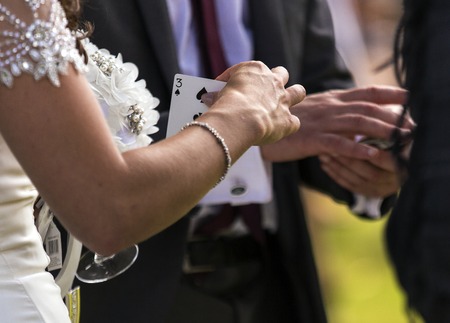 Shot of a bride choosing a card from a magician at a wedding