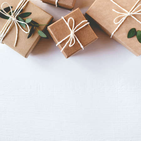 Craft gift boxes on white wooden background. Copy space for text. Eco concept