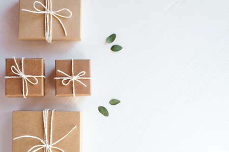Craft gift boxes on white wooden background. Copy space for text. Eco conceptの写真素材