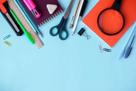 School supplies on blue background. Top view. Copy space.