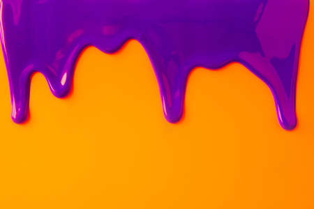 Purple paint leaking down orange background. Close up.の写真素材
