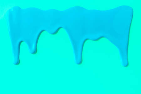 Blue paint leaking down trendy cyan background. Close up.の写真素材