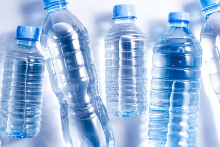 Several plastic water bottles on white background. The concept of plastic free pattern
