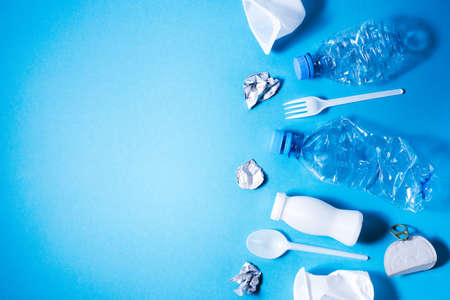 Plastic trash on blue background, eco concept image with copy space.の写真素材