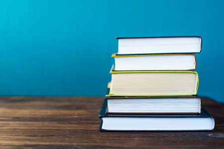 Books on table in front of chalk board. Back to school concept with copy space for textの写真素材