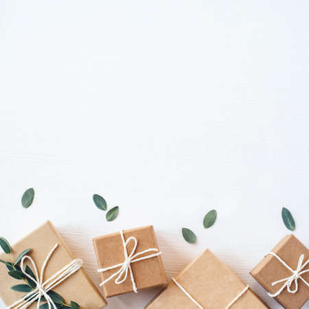 Craft gift boxes on white wooden background. Copy space for text. Eco concept