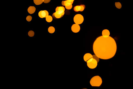 Dark abstract background with bright gold bokeh