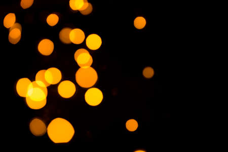 Dark abstract background with bright gold bokehの写真素材