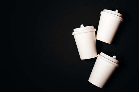 Three paper cups for coffee or tea on black background. Copy space for text.の写真素材