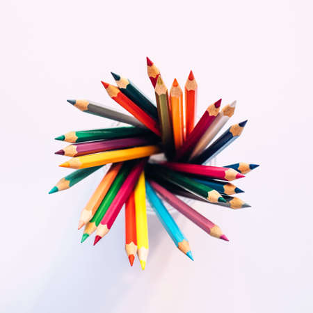 Colored pencils in a glass on a white background. The view from the top. Copy spaceの写真素材