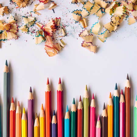 Row of colored sharpened crayons and colored shavings on paper backgroundの写真素材