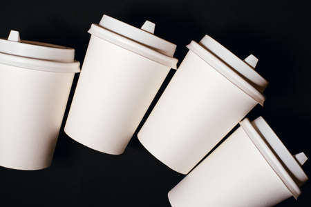 Four paper cups for coffee or tea on black background.の写真素材