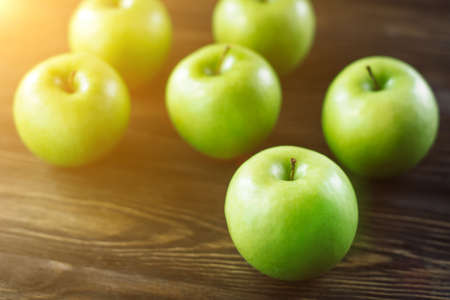 Group of green apples on brown wooden background. Close upの写真素材