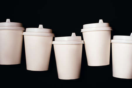 Five paper cups for coffee or tea isolated on black background.の写真素材