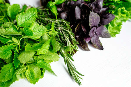 Leaves of fresh green salad, Basil, rosemary and Melissa on a wooden table. Top viewの写真素材