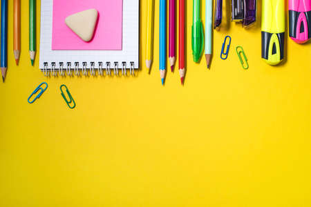 School supplies on yellow background. Top view. Copy space.