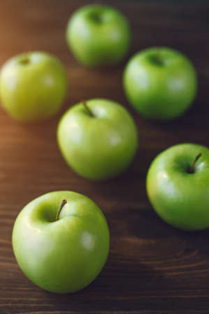 Group of green apples on brown wooden background. Close upの写真素材