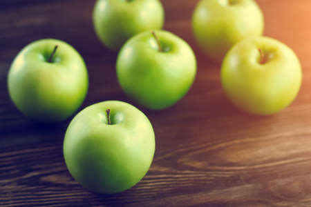 Group of green apples on brown wooden background. Close upの写真素材