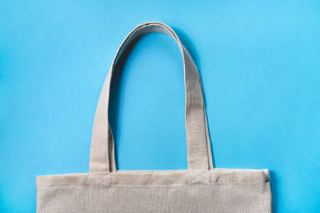 Fabric eco-bag on blue background. Flat lay, close up.の写真素材