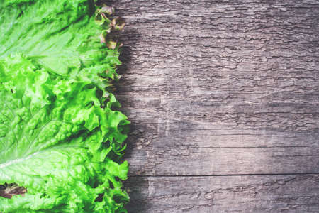 Leaves of fresh green salad on wooden table. Copy space.の写真素材
