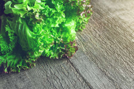 Bunch of fresh green salad on wooden table. Copy space.の写真素材