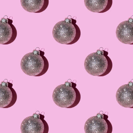Pattern made of silver balls on pink background. Christmas or New Year concept. Flat lay.の写真素材
