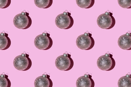 Pattern made of silver balls on pink background. Christmas or New Year concept. Flat lay.の写真素材
