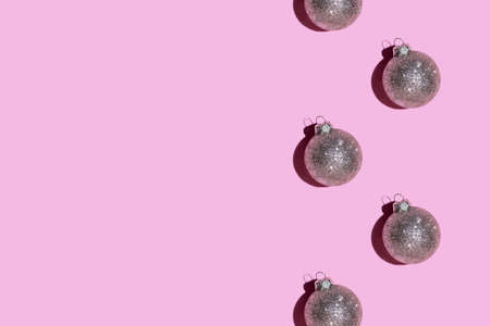 Pattern made of silver balls on pink background. Christmas or New Year concept. Flat lay. Copy space.の写真素材