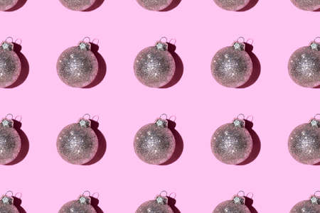Pattern made of silver balls on pink background. Christmas or New Year concept. Flat lay.の写真素材