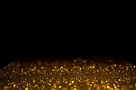 Golden abstract bokeh on black background. Holiday conceptの写真素材